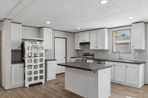 a kitchen with stainless steel appliances granite countertop a stove a sink and a microwave