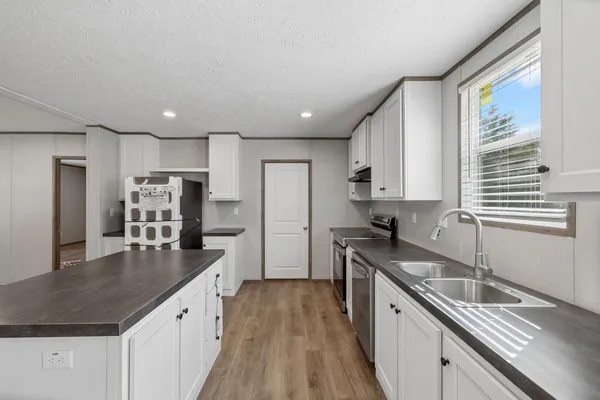 a kitchen with granite countertop a sink and a stove top oven