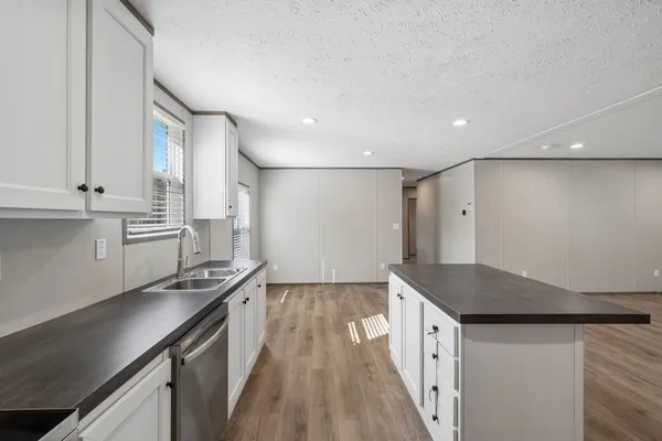 a kitchen with a sink a refrigerator and a stove top oven