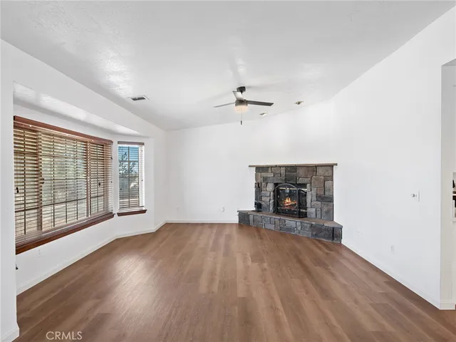 a view of empty room with wooden floor and fireplace