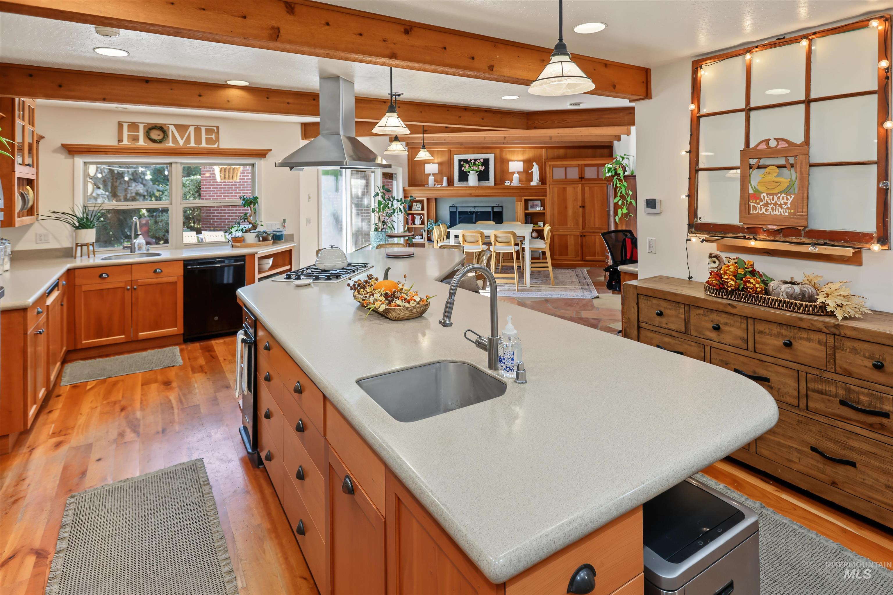 508 East Elm Avenue Parma, ID 83660 - Photo 9 of 50 Kitchen featuring a large island with an undermount sink, warm wood cabinetry, wood-finish flooring, and exposed wood ceiling beams