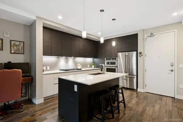 a kitchen with stainless steel appliances a stove a refrigerator a sink and a refrigerator