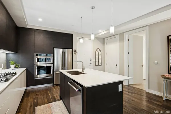 a kitchen that has a kitchen island wooden cabinets and stainless steel appliances