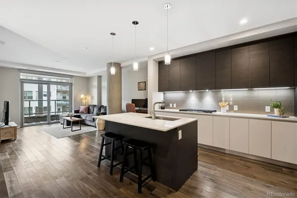 a kitchen with a sink a stove cabinets and wooden floor