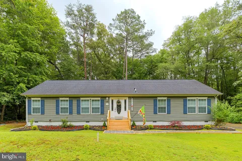 a front view of a house with swimming pool and chairs