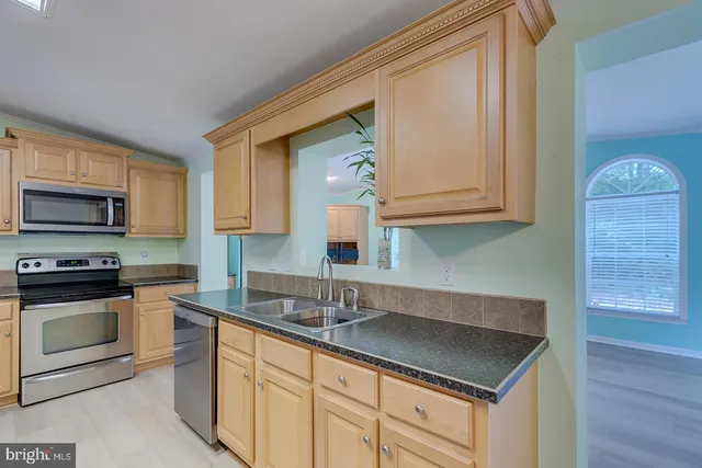 a view of empty room with kitchen and fireplace