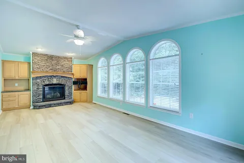 an empty room with a fan & a window