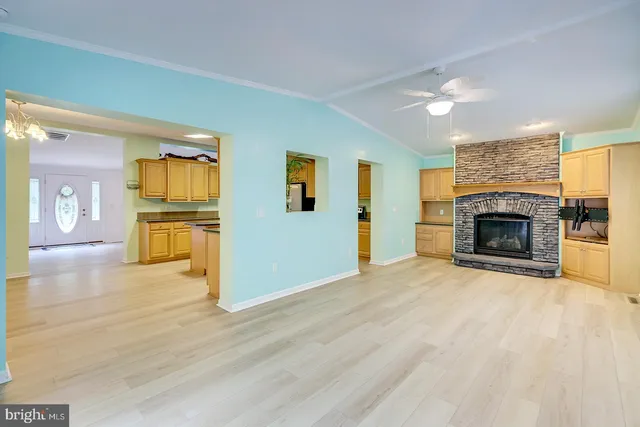 an empty room with windows and fan