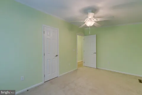 an empty room with a ceiling fan and a chandelier fan
