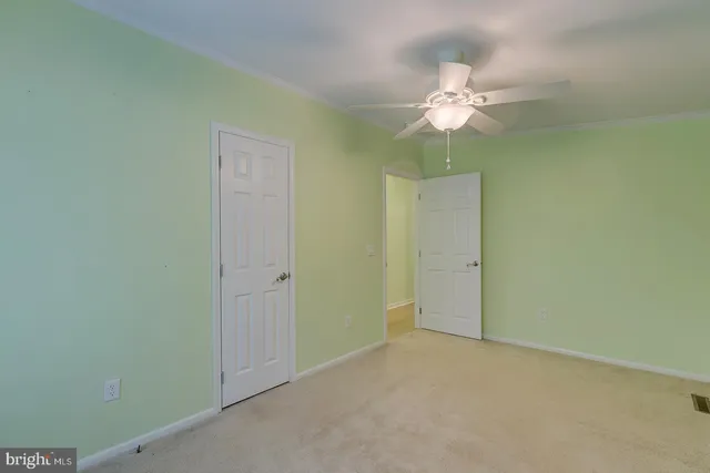 an empty room with a ceiling fan and a chandelier fan