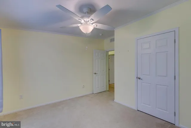 an empty room with a chandelier fan and a window