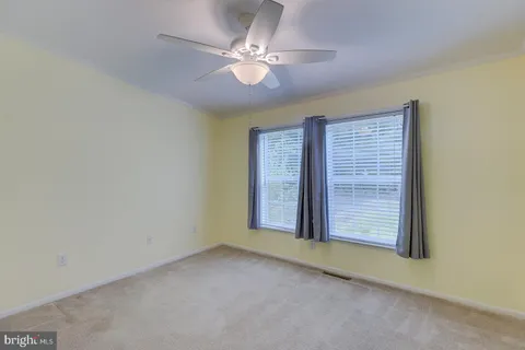 an empty room with a chandelier fan and a chandelier fan