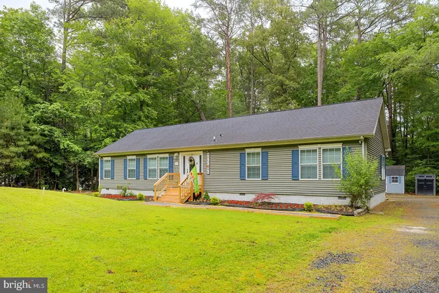 a front view of a house with yard patio and green space