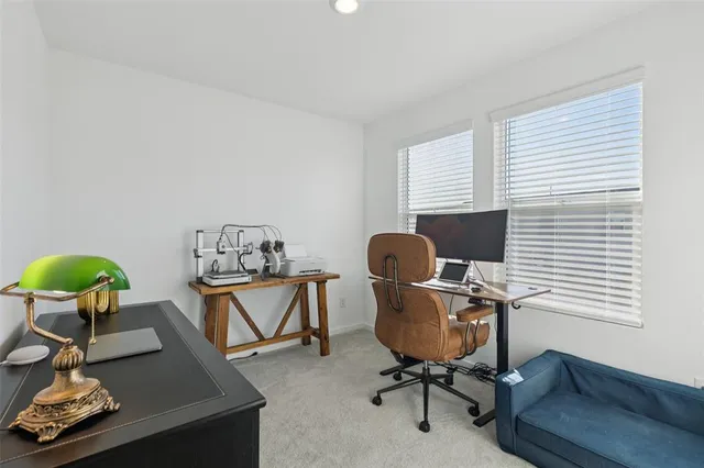 a view of a workspace with furniture and a window