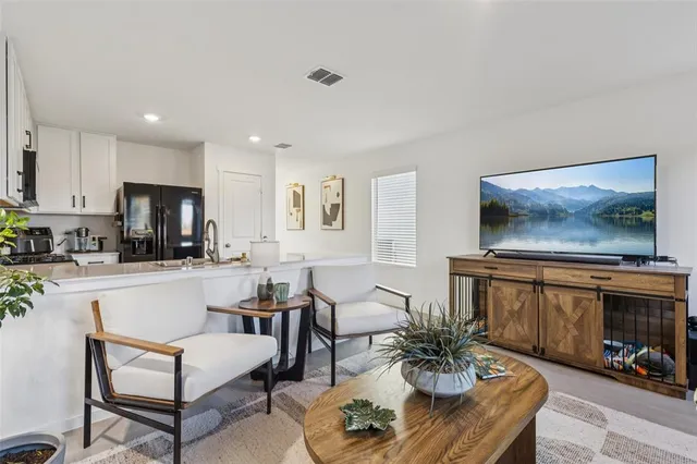 a living room with furniture dining area and a flat screen tv