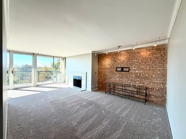 a view of an empty room with a fireplace and a window