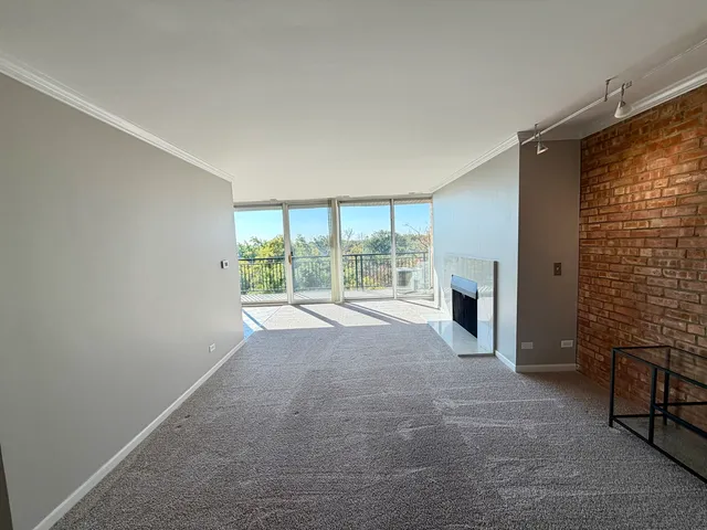 a view of an empty room with a fireplace and a window