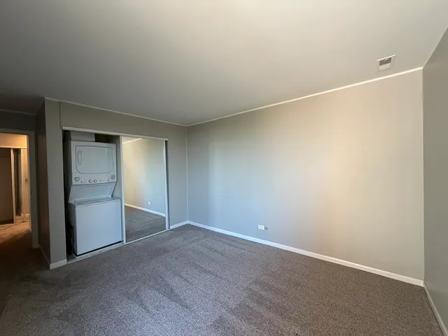 an empty room with closet and windows