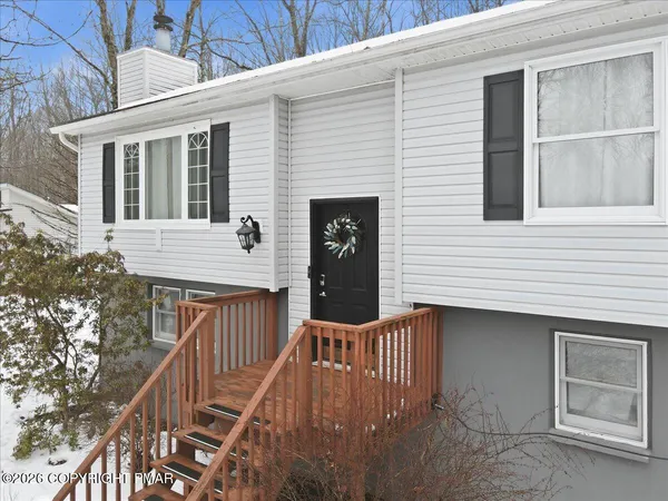 a dining room with wooden floor a chandelier a wooden table and chairs
