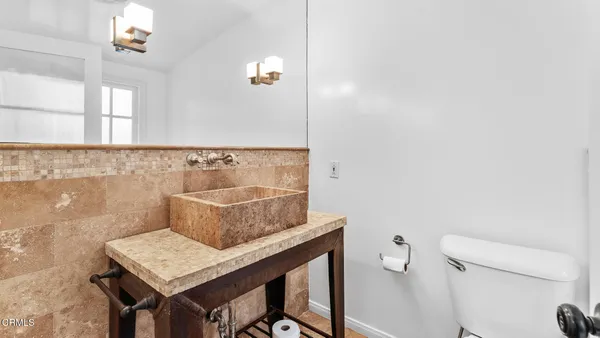 a bathroom with a sink a toilet and a mirror