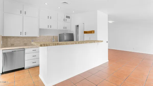 a kitchen with granite countertop white cabinets and white appliances
