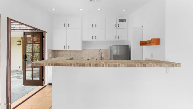 an empty room with kitchen view and window