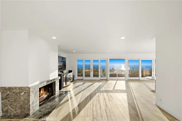 a view of a living room a dining room with a fireplace and a large window