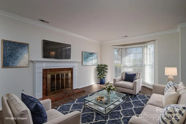 a living room with furniture a fireplace and a flat screen tv