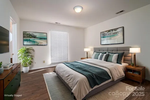 a bedroom with bed and a painting on the wall