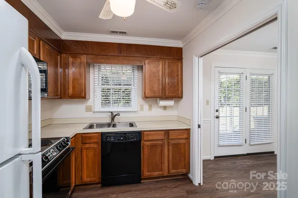 a kitchen with granite countertop a sink cabinets stainless steel appliances and a window