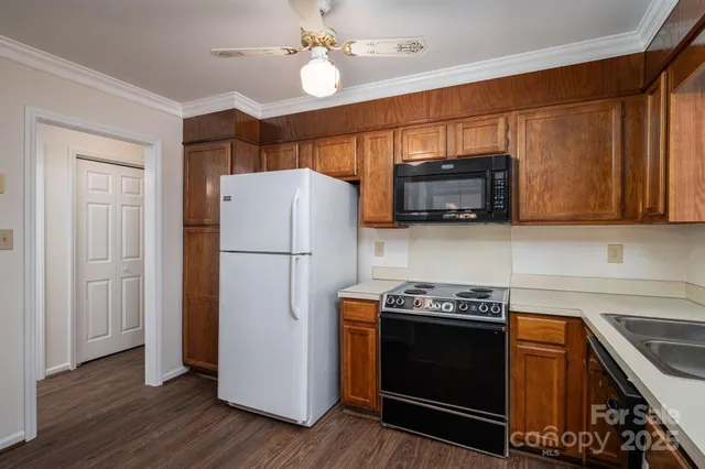 a kitchen with stainless steel appliances granite countertop a refrigerator a sink a stove a microwave and wooden cabinets