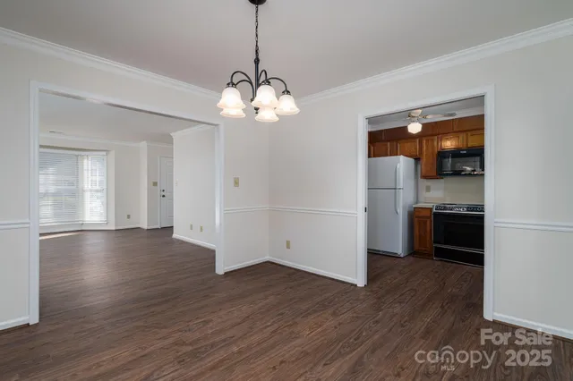 an empty room with wooden floor fireplace and windows