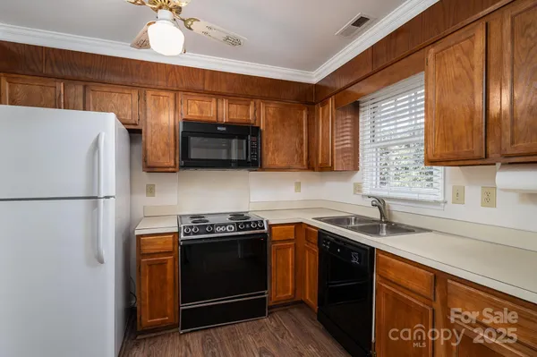 a kitchen with stainless steel appliances granite countertop a refrigerator a sink a stove a microwave and wooden cabinets