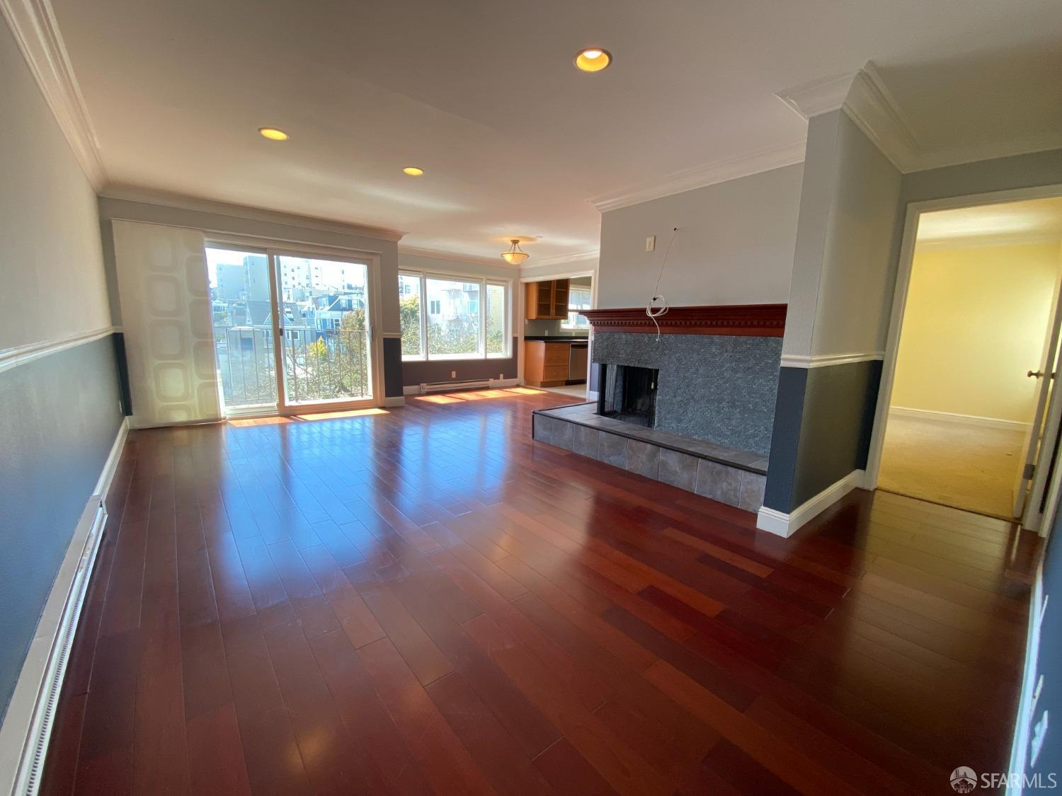 a living room with hard wood floors and a fireplace