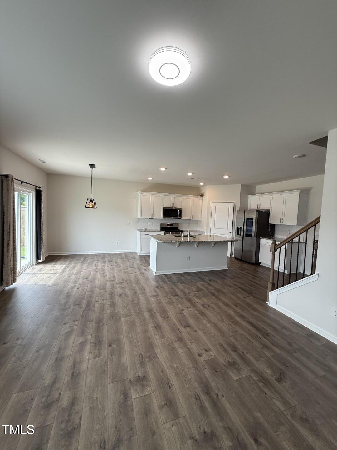 2018 Fletchers Ridge Drive Durham, NC 27703 - Photo 18 of 41 a view of kitchen and empty room with wooden floor