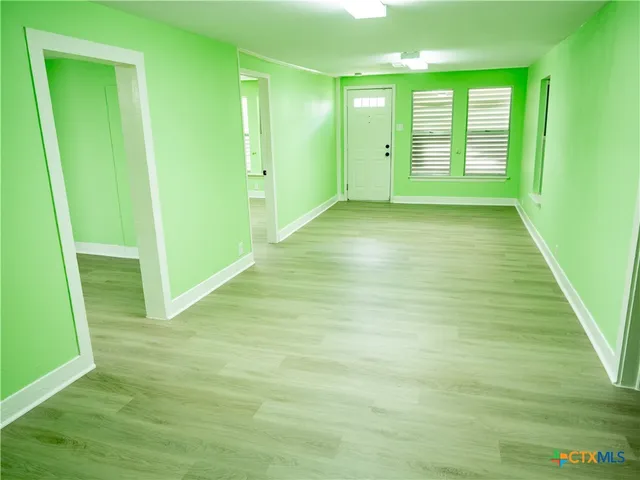 a view of an empty room with window and stairs