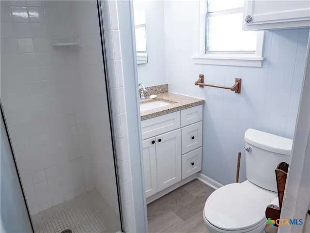 a bathroom with a granite countertop toilet and a sink