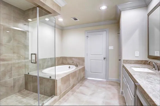 a bathroom with a tub sink shower and mirror