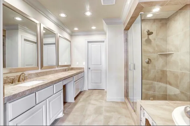 a spacious bathroom with a granite countertop sink a mirror and a shower