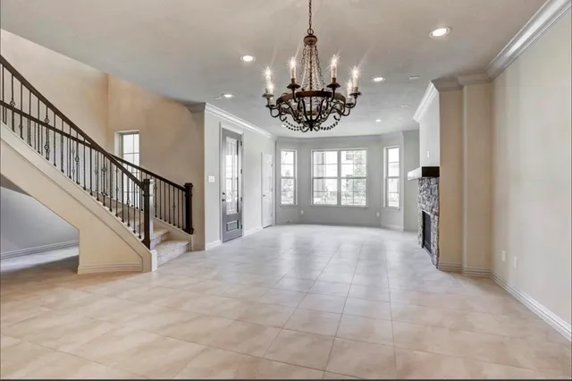 a view of an empty room with a window and fireplace