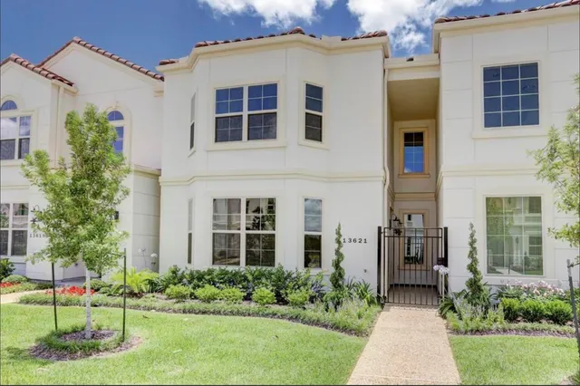 a front view of a house with a yard and trees