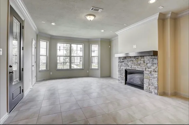 a view of an empty room with a fireplace and a window
