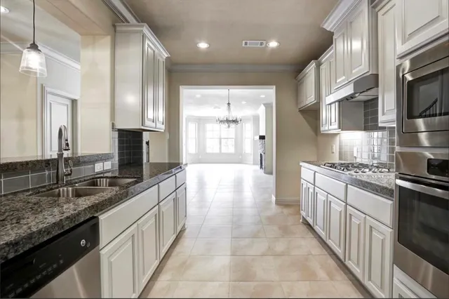 a large kitchen with stainless steel appliances granite countertop a lot of counter space and a sink