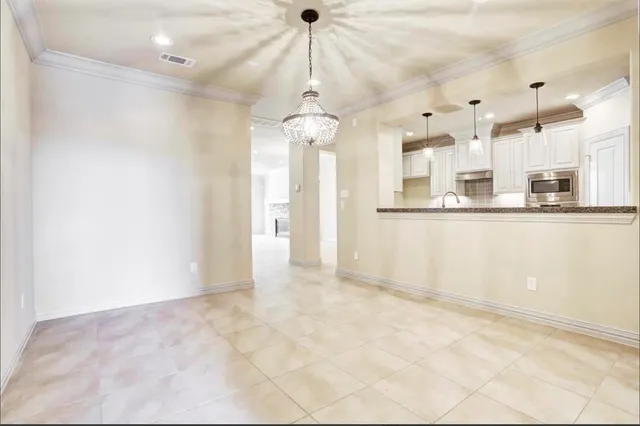 a view of a kitchen with stainless steel appliances granite countertop cabinets and a chandelier