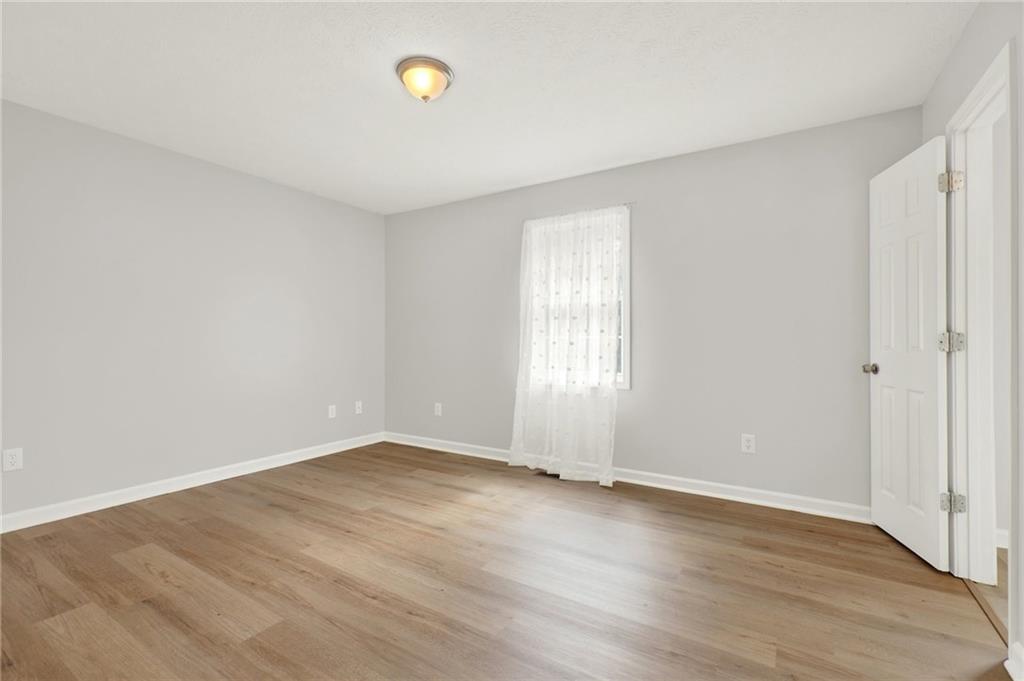 76 Picklesimer Road Southwest Cartersville, GA 30120 - Photo 27 of 43 an empty room with wooden floor and windows