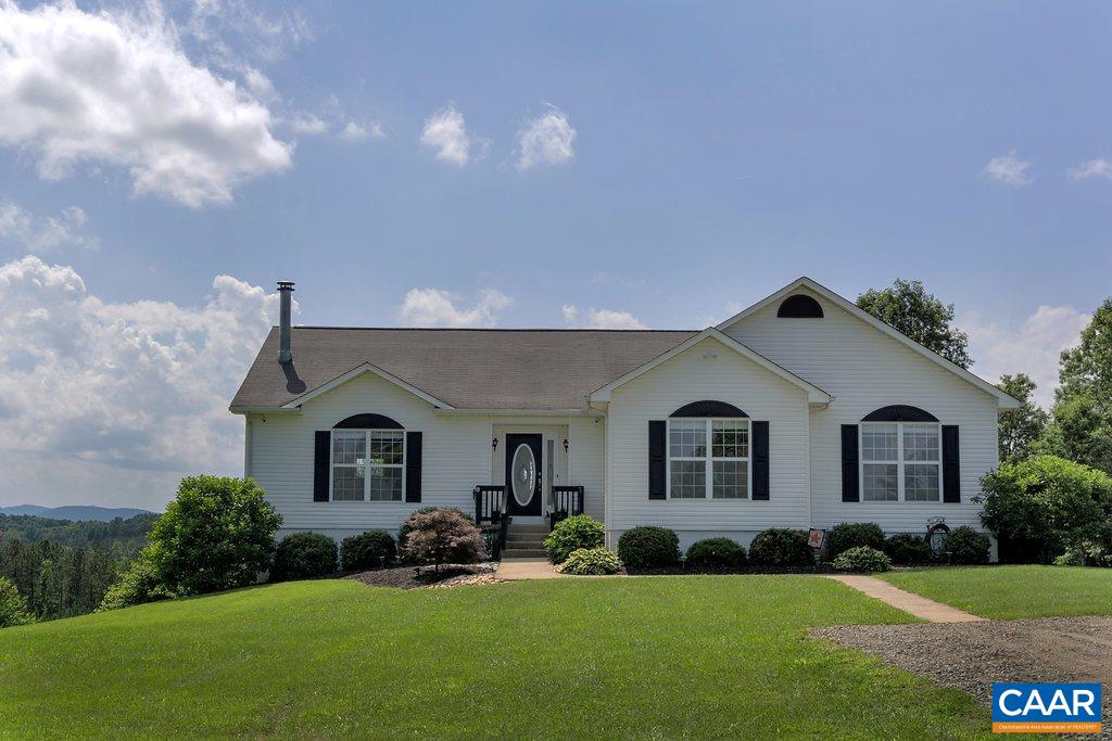 a front view of a house with a garden and yard