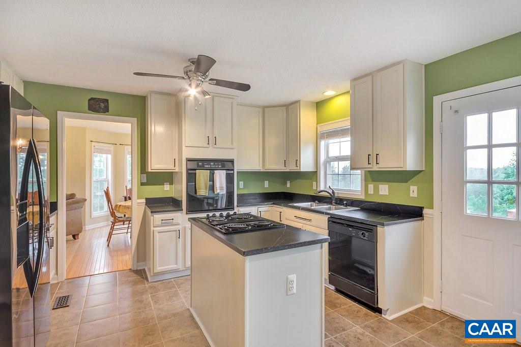8424 Chestnut Grove Road Esmont, VA 22937 - Photo 11 of 42 a kitchen with stainless steel appliances a stove a sink a refrigerator cabinets and dining table