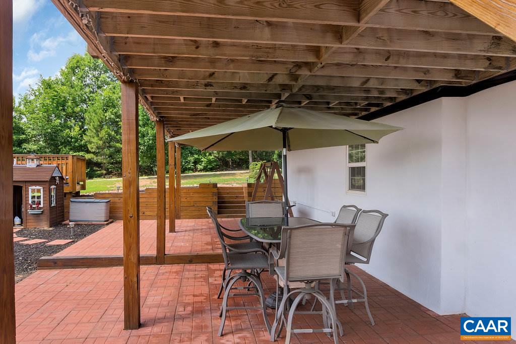 8424 Chestnut Grove Road Esmont, VA 22937 - Photo 31 of 42 a view of a patio with table and chairs under an umbrella
