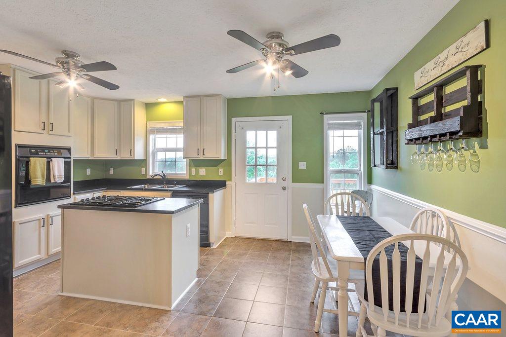 8424 Chestnut Grove Road Esmont, VA 22937 - Photo 9 of 42 a kitchen with stainless steel appliances granite countertop a stove top oven a sink a dining table and chairs