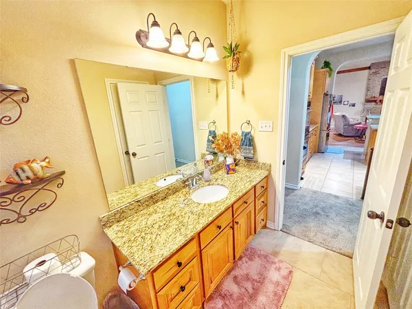 a bathroom with a granite countertop sink and a mirror